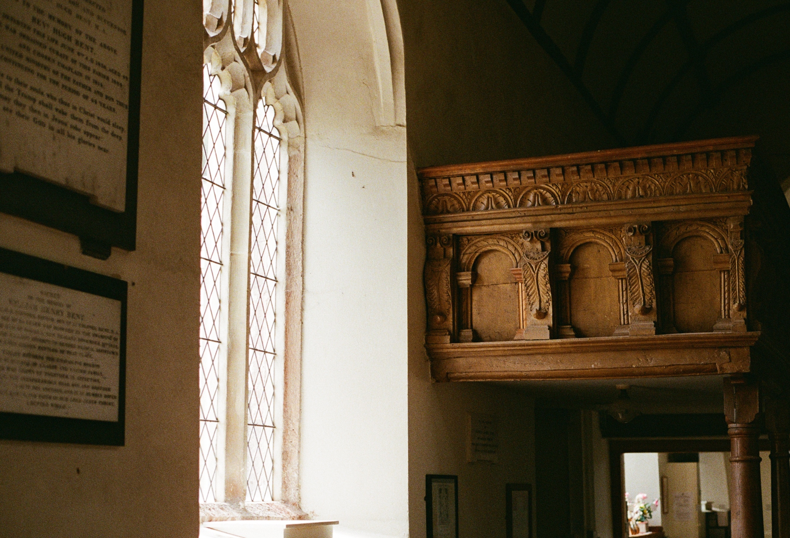 carved wooden gallery lit by a leaded window